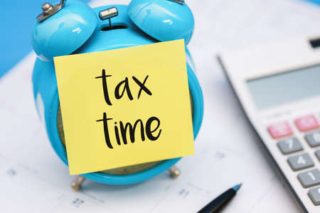 Tax Time Written on Sticky Note, Sticking on Alarm Clock.の写真素材