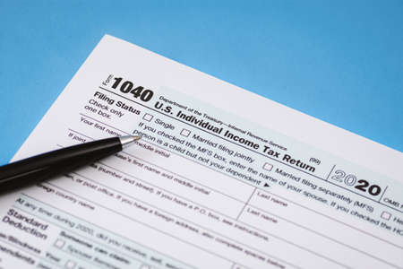 Close Up of Tax Form 1040 on Light Blue Backgroundの写真素材