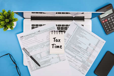 Tax Time. Tax Form 1040 on Office Desk on Light Blue Background