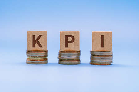 KPI, Key Performance Indicators Word on Wood Block Against Blue Backgroundの写真素材