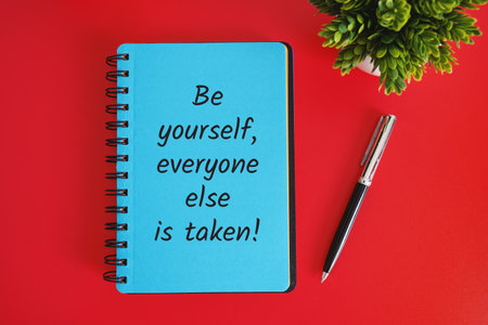 "Notebook with Handwritten Life Lesson" - A notebook with a handwritten life lesson on a red background.の写真素材