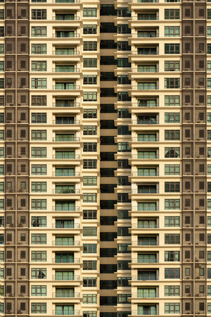 A modern high-rise building with many windows and balconies.の写真素材