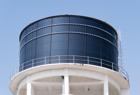 Large elevated industrial water tank against a clear blue sky.の写真素材