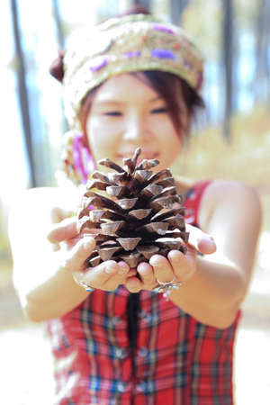 Woman holds big pine seedの写真素材