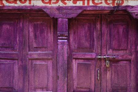 Old purple wood door with napalese letter over doorの写真素材
