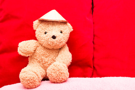 Brown teddy bear on red backgroundの写真素材