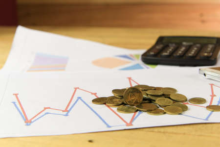 Gold coins on finance graph report and blacak calculatorの写真素材