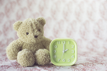 bear doll and green clockの写真素材