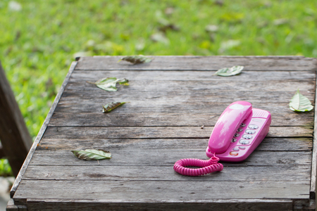 Pink telephone on old talble in natureの写真素材