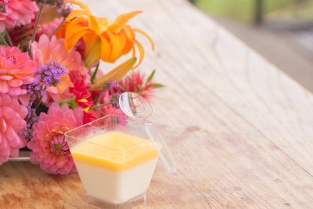Pana cotta in square plastic cup on wood tableの写真素材