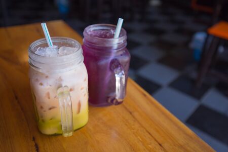 color cold drink and milky cold drink on wood table with food backgroundの写真素材