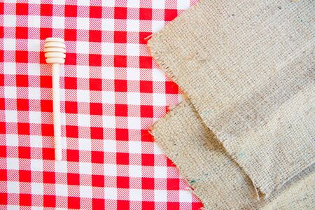 Honey spoon, kitchen utensil on red and white checker table runner