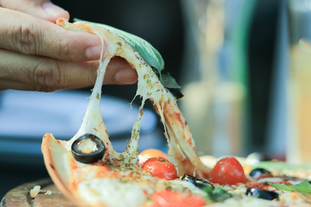 Anchovy think yummy pizza, Italian famous dish with salty fish, black olive, red cherry tomoto, permesan cheese and origano as ingredientの写真素材