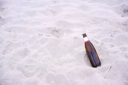 Garbage or left trash on sand. Beach is dirty of plastic, glass and rubbish. waste reduction concerning conceptの写真素材