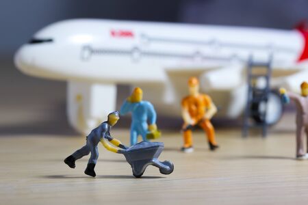 Airplane engineer, airport worker, aircraft people working in fixing, repairing the runway and checking the airplane. Many level of miniature company employee and employer figure as flight conceptの写真素材