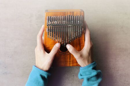 Kalimba or mbira is an African musical instrument.Traditional to the Shona people of Zimbabwe. Kalimba made from  wooden board with metal, play on  hands and plucking the tines with the thumbs. Instrument  on tableの写真素材