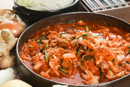 Kimchi preparation. Korean cuisine famous side dish, fermented vegetables, cabbage, radish, spicy and smelly seasonings including apple or pear, onions, garlic, ginger & spring onionの写真素材