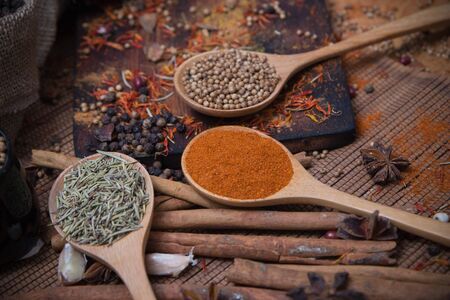 Spicy condiment, herbal aroma dry food for Asian cookin on wood  cutter with dry seed and colorful powder for kitchen ingredientの写真素材
