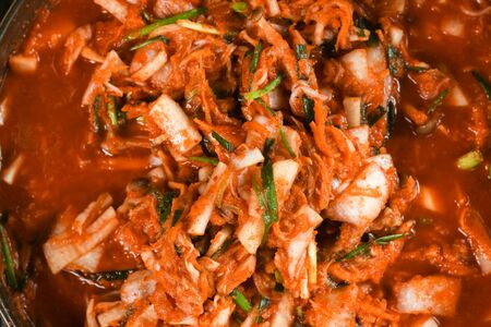 Kimchi,Korean cuisine famous side dish, traditional side dish and fermented vegetables, cabbage and radish, spicy and smelly seasonings including apple or pear, onions, garlic, ginger, spring, onion and mushroom.の写真素材