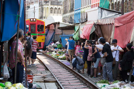 Samutsakorn, Thailand - November 11, 2018 : Maeklong Railway Market, umbrella and shade along the railway of old yellow Thai train at Mae Klong station. Unseen destination of Thailandのeditorial素材