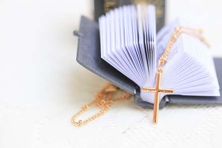 Gold Christ cross lace with holy bible, black cover. European religion conceptual for Christian...