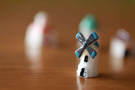 Small house, tiny windmill, little tower as miniature hometown as villate toy on wood floor in concept of living of idea living together for eco friendly as wind powerの写真素材