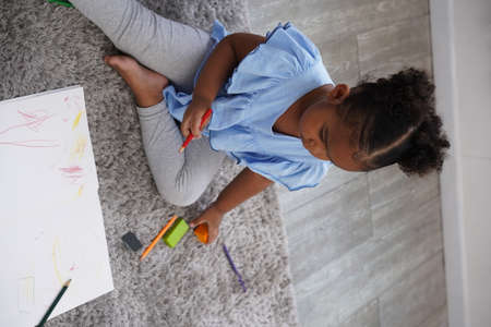 A female kid playing in the home school with wooden block as creative learning. African girl is playing together with fun.の写真素材