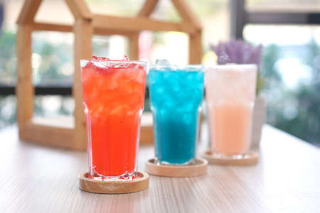Refreshing cold beverage for summer on ice. Colorful summer drink in tall glass with wood saucer for hot day and party.の写真素材