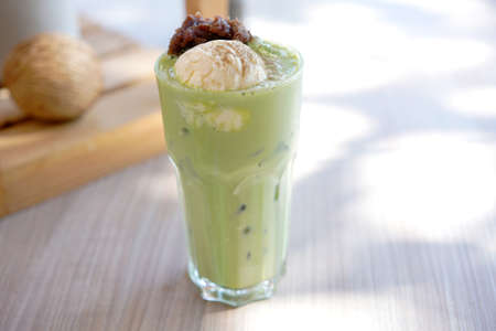 Latte art hot coffee with tulip milk latte art on top of white ceramic glass set on table in coffee shop Hot chocolate drink with white foam on top in short cup with New York cake as dessert menu.の写真素材