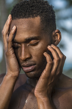 Photo shoot for a black handsome guy, water runs down the face and bodyの写真素材