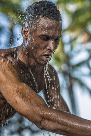 Photo shoot for a black handsome guy, water runs down the face and bodyの写真素材