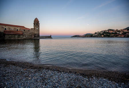 October, 2018, Collioure, France. Sunset in the bay with a view of the tower and the rising moon