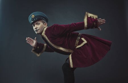 a man portraying a glamorous character in a maroon suede tailcoat and capの写真素材