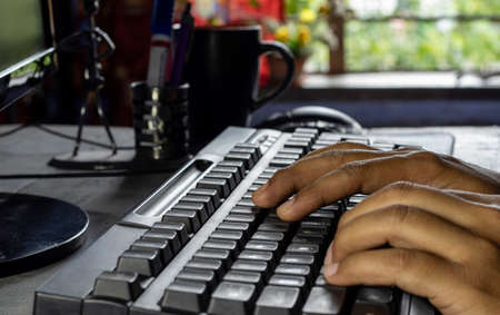 selective focus on the return key or enter key of black keyboard of desktop being pressed by a human...