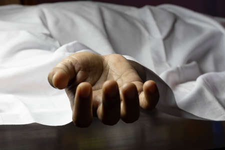 an Indian or Asian person laying dead with outstretched hand during COVID-19 or corona virus...