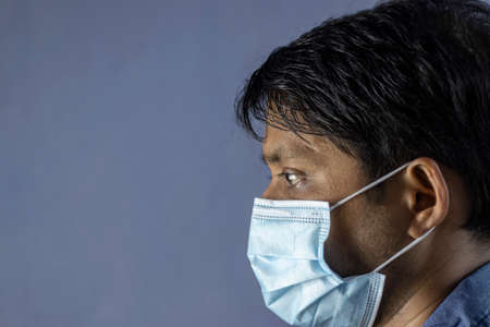 side face of an Indian man wearing surgical nose mask for corona virus or covid-19 protection on...
