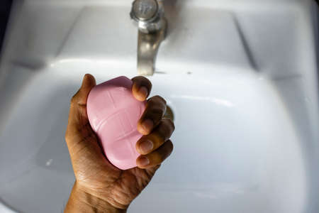 high angle view of male washing hands with plain soap in wash basin during novel corona virus outbreakの写真素材
