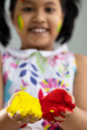 Selective focus on colorful palms of a pretty Indian girl child during holiの写真素材