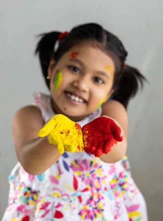 Selective focus on colorful palms of a pretty Indian girl child during holiの写真素材
