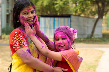 Indian mother and daughter in colorful faces during Holiの写真素材