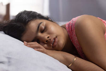 An Indian asian woman sleeping peacefully on bed