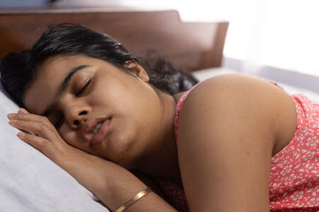 An Indian asian woman sleeping peacefully on bedの写真素材