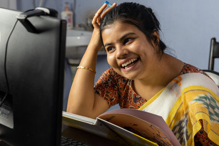 Close up of an Indian woman in saree working on computer at home, work from home conceptの写真素材