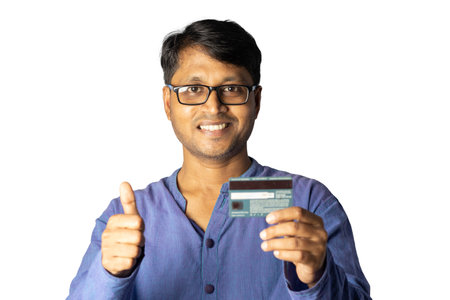 A middle aged Indian male wearing spectacles shows thumbs up holding a credit or debit card on white backgroundの写真素材