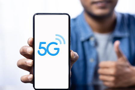 Close up of a smart phone showing 5G network held in hand by a maleの写真素材