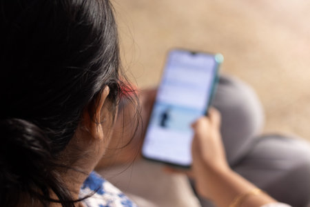 An Indian woman with smart phone at homeの写真素材