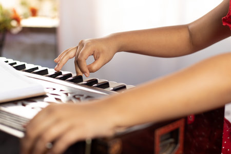 Hands of an Indian girl child plying harmonium with selective focus on white backgroundの写真素材