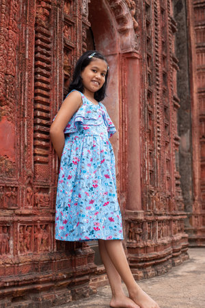 A pretty Indian girl child near a terracotta temple of West Bengal