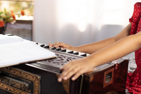 Hands of an Indian girl child plying harmonium with selective focus on white backgroundの写真素材