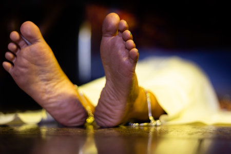 Feet of an Indian or Asian female dead body lying on floor in a dark roomの写真素材
